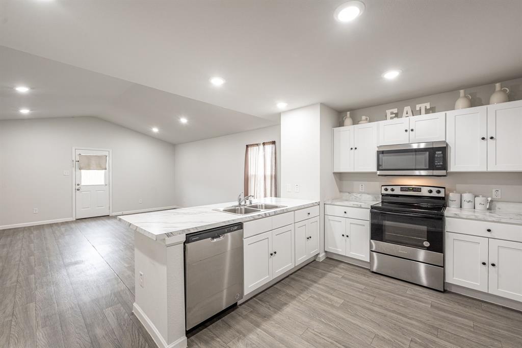 1106 Ripplewood Circle Chandler, TX 75758 - Photo 2 of 24 a kitchen with stainless steel appliances granite countertop a stove a sink and white cabinets