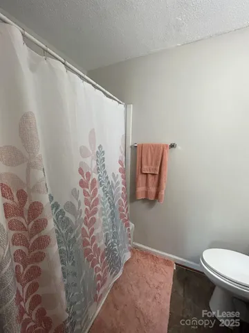 a bathroom with a toilet and a shower curtain