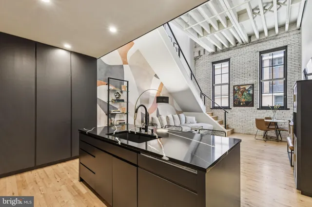 a kitchen with stainless steel appliances granite countertop a sink and a wooden floors