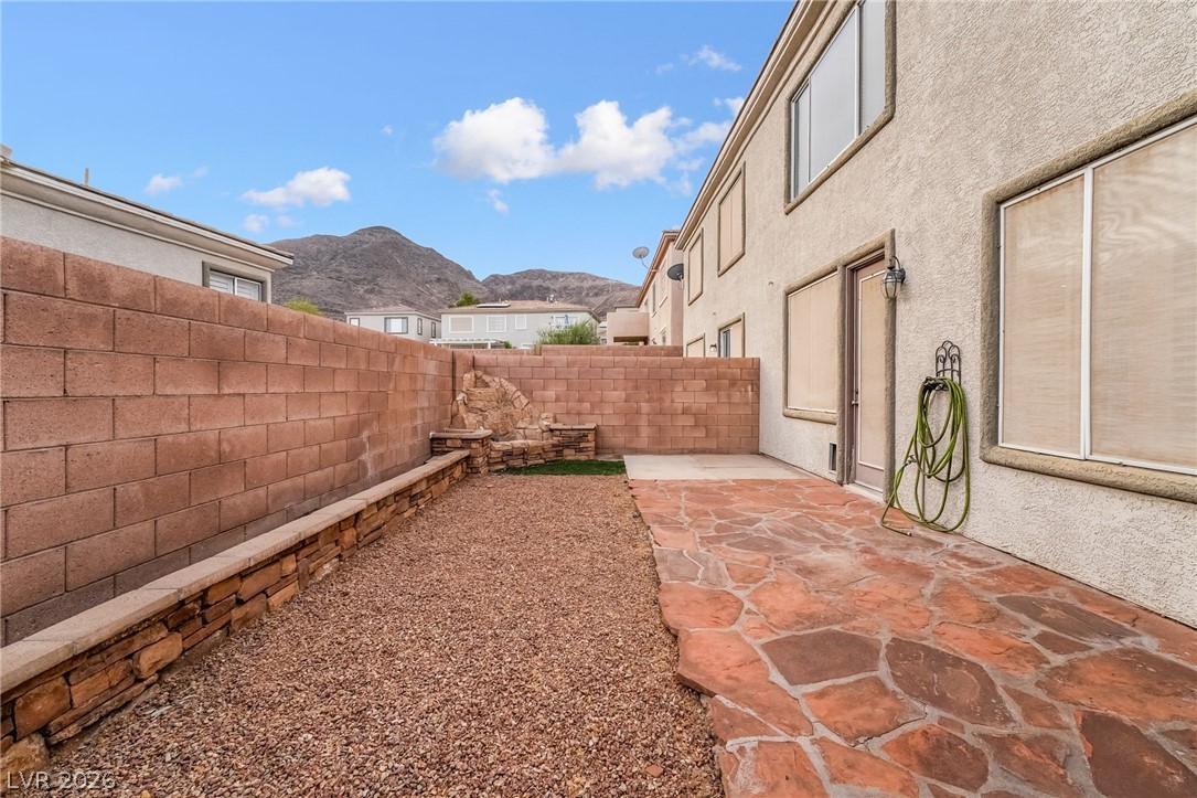 224 Positive Point Street Henderson, NV 89012 - Photo 41 of 44 An enclosed backyard patio features flagstone paving and a high stone block privacy wall.