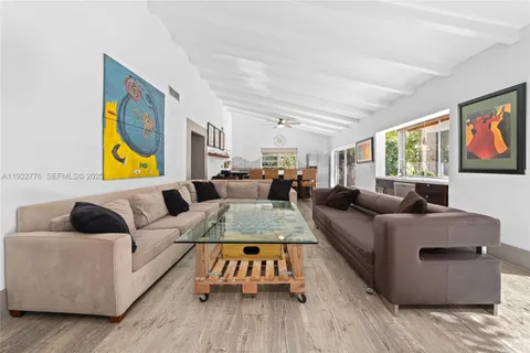 a living room with furniture and painting on the wall next to a window