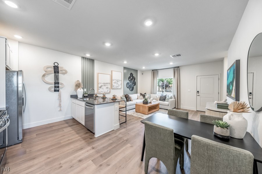 5882 Grand Row Way Reno, NV 89523 - Photo 6 of 19 a living room with stainless steel appliances kitchen island granite countertop furniture and wooden floor
