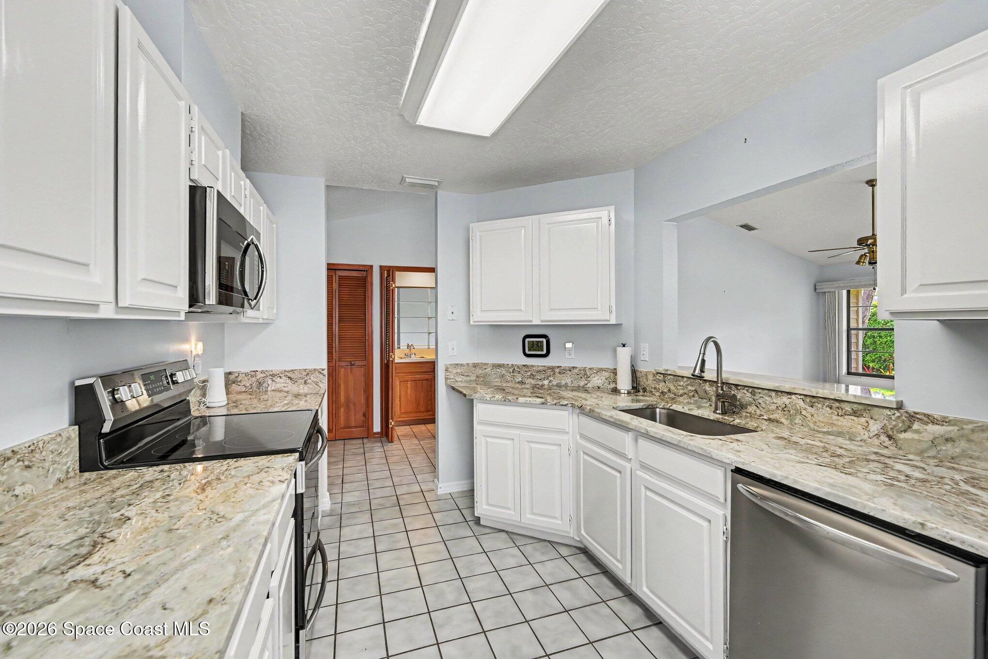 899 Ridge Lake Drive Melbourne, FL 32940 - Photo 11 of 34 a kitchen with a sink stove and cabinets