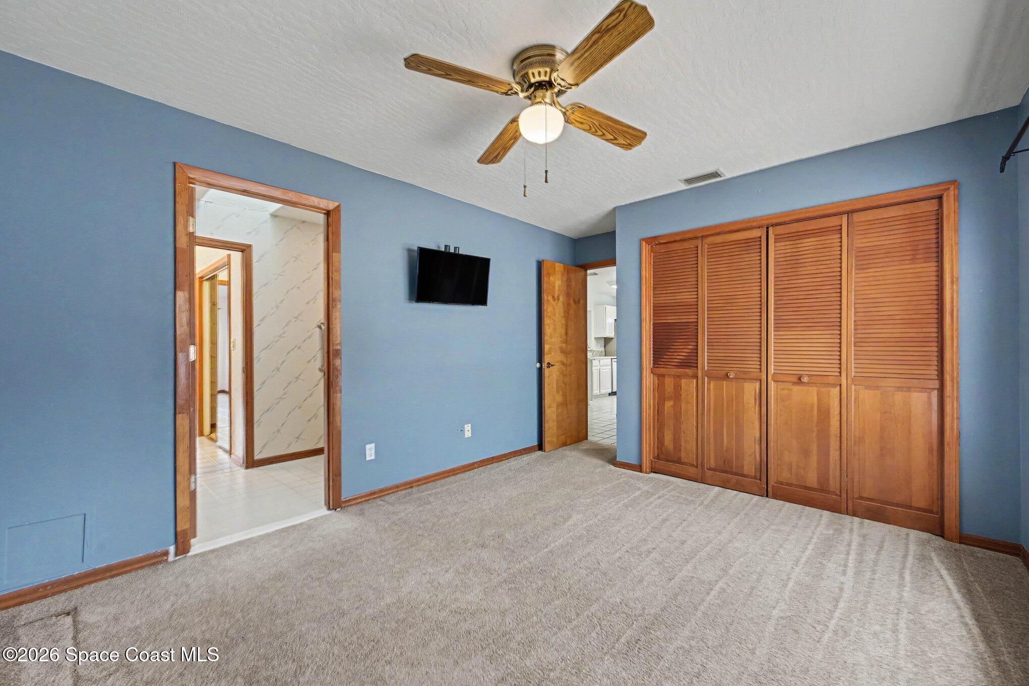 899 Ridge Lake Drive Melbourne, FL 32940 - Photo 18 of 34 an empty room with closet and a ceiling fan