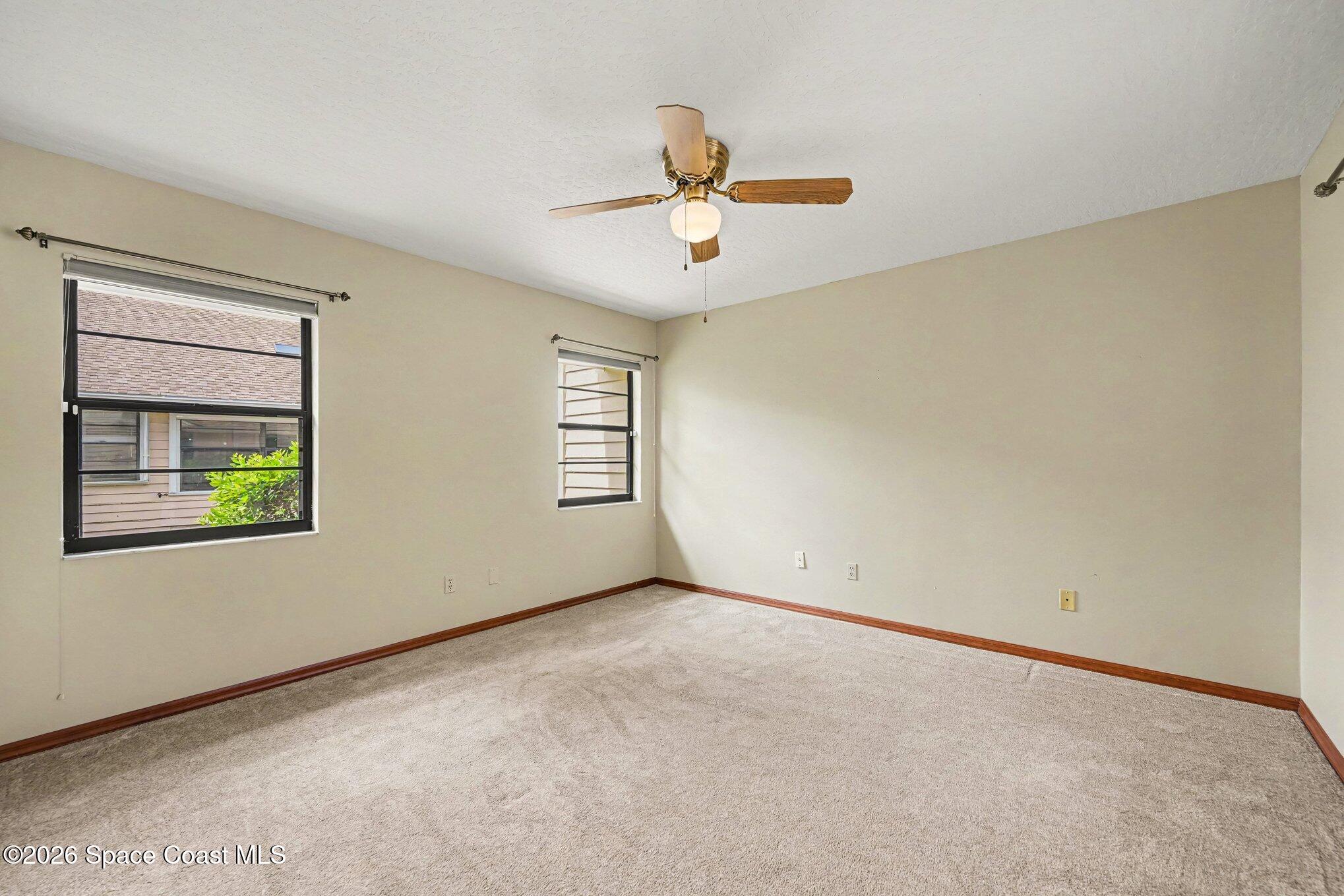 899 Ridge Lake Drive Melbourne, FL 32940 - Photo 21 of 34 an empty room with windows and ceiling fan