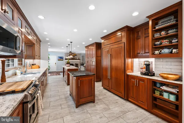 a kitchen with stainless steel appliances granite countertop a sink a stove and a refrigerator