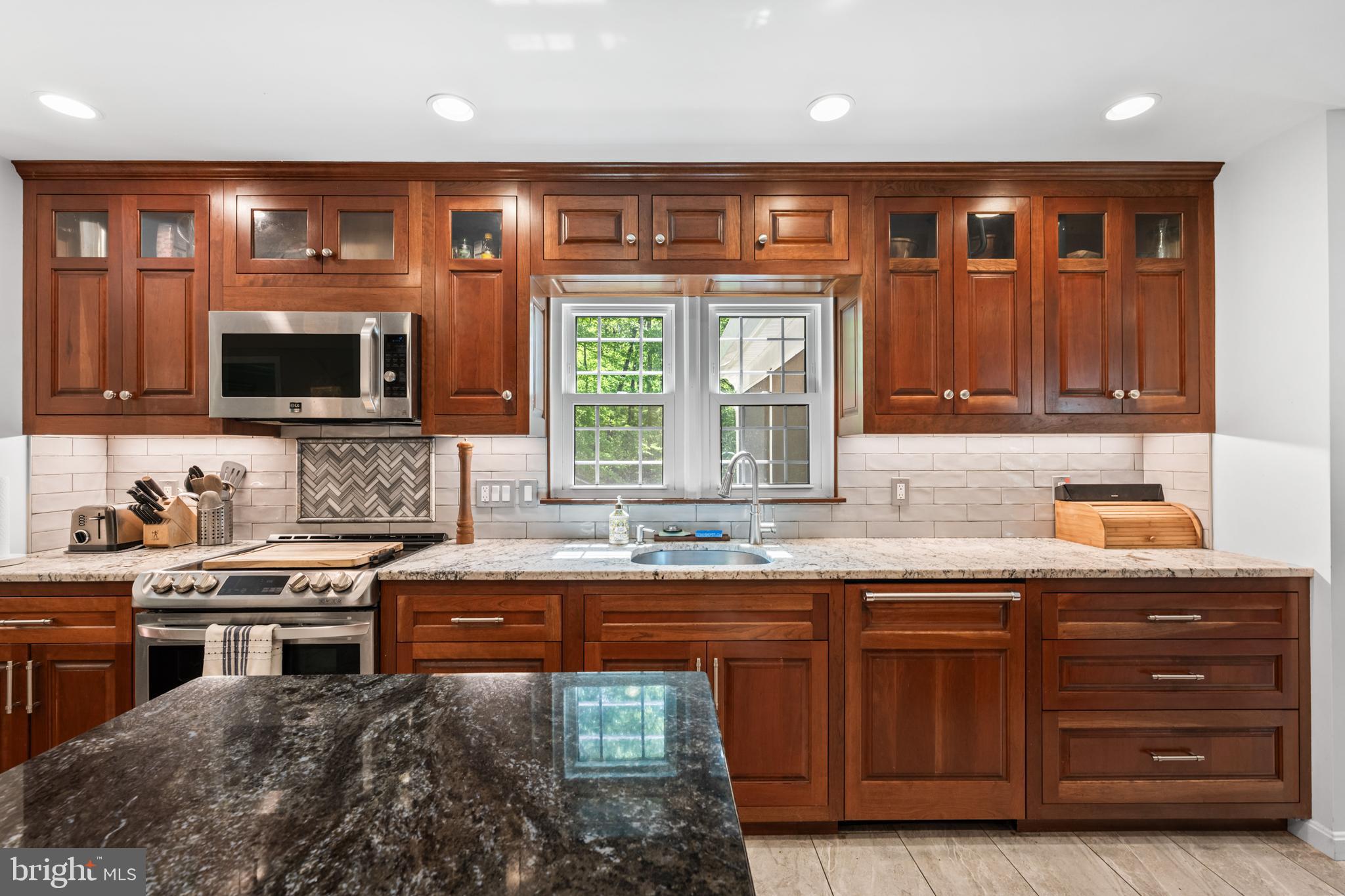 7362 Clifton Road Clifton, VA 20124 - Photo 10 of 53 a kitchen with stainless steel appliances granite countertop a stove a sink and a microwave