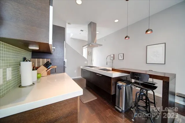 a kitchen with a sink a stove and chairs