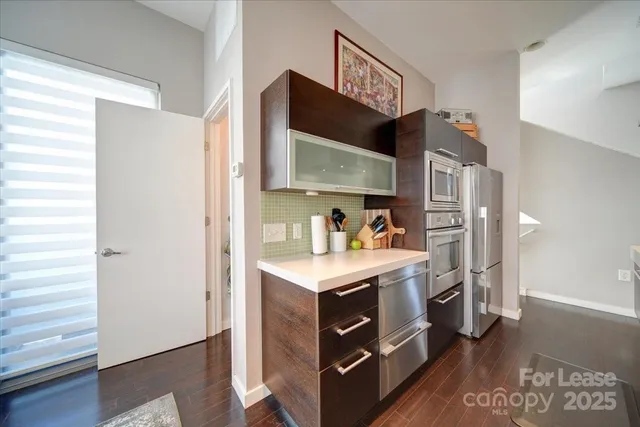 a view of kitchen with stainless steel appliances granite countertop a stove and a refrigerator