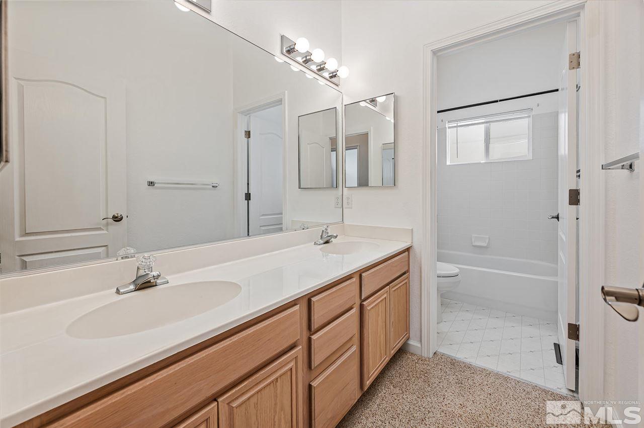 705 Gold Run Court Reno, NV 89521 - Photo 15 of 17 a bathroom with a double vanity sink a mirror and a bathtub