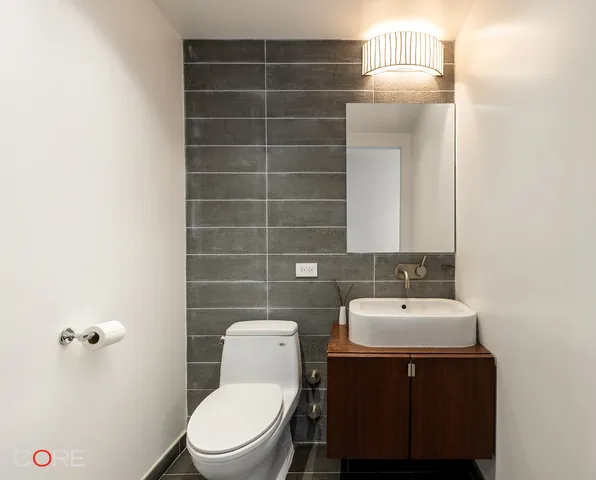 a bathroom with a sink a toilet and mirror