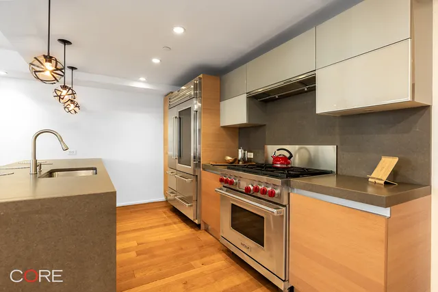 a kitchen with stainless steel appliances granite countertop a stove a sink and a refrigerator