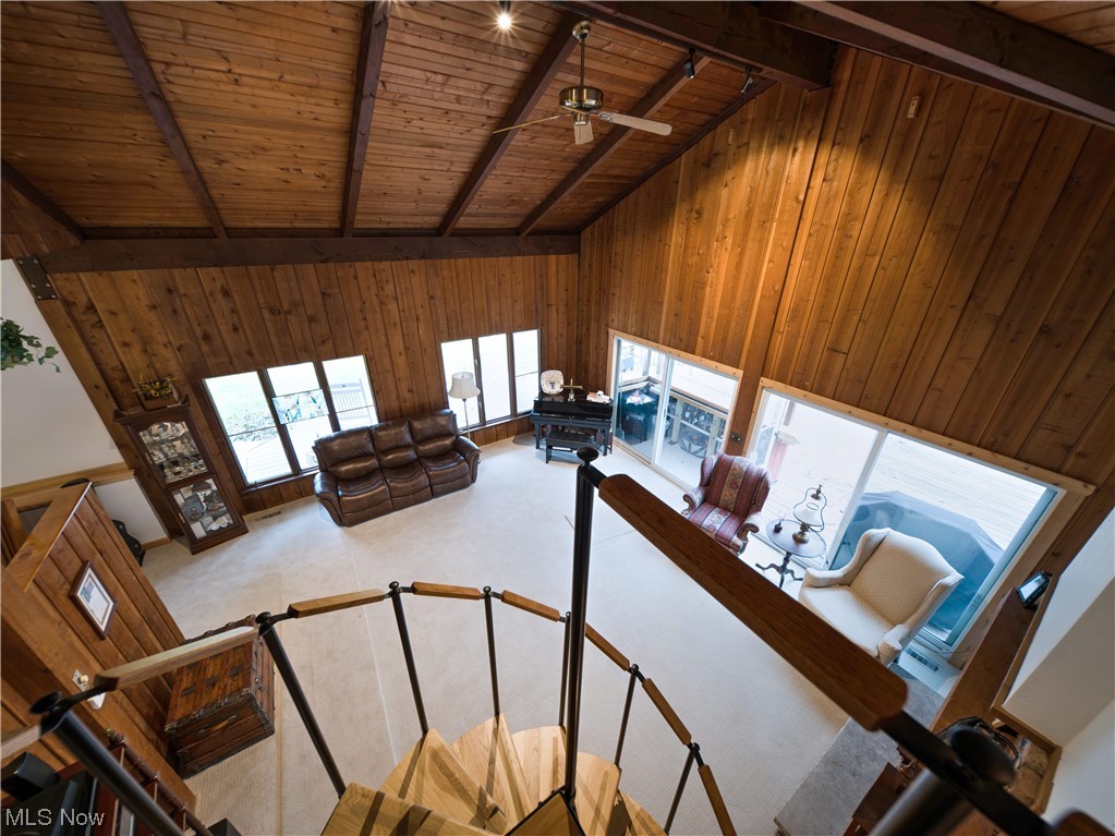 9696 Thwing Road Chardon, OH 44024 - Photo 15 of 35 Staircase featuring wood ceiling, high vaulted ceiling, wooden walls, ceiling fan, and beamed ceiling From bonus suite looking down to great room