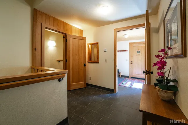 a view of a hallway with bathroom and wooden floor