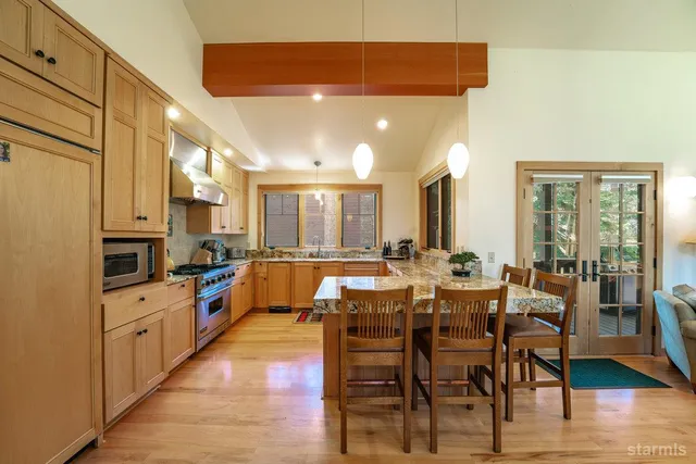a large kitchen with cabinets table and chairs