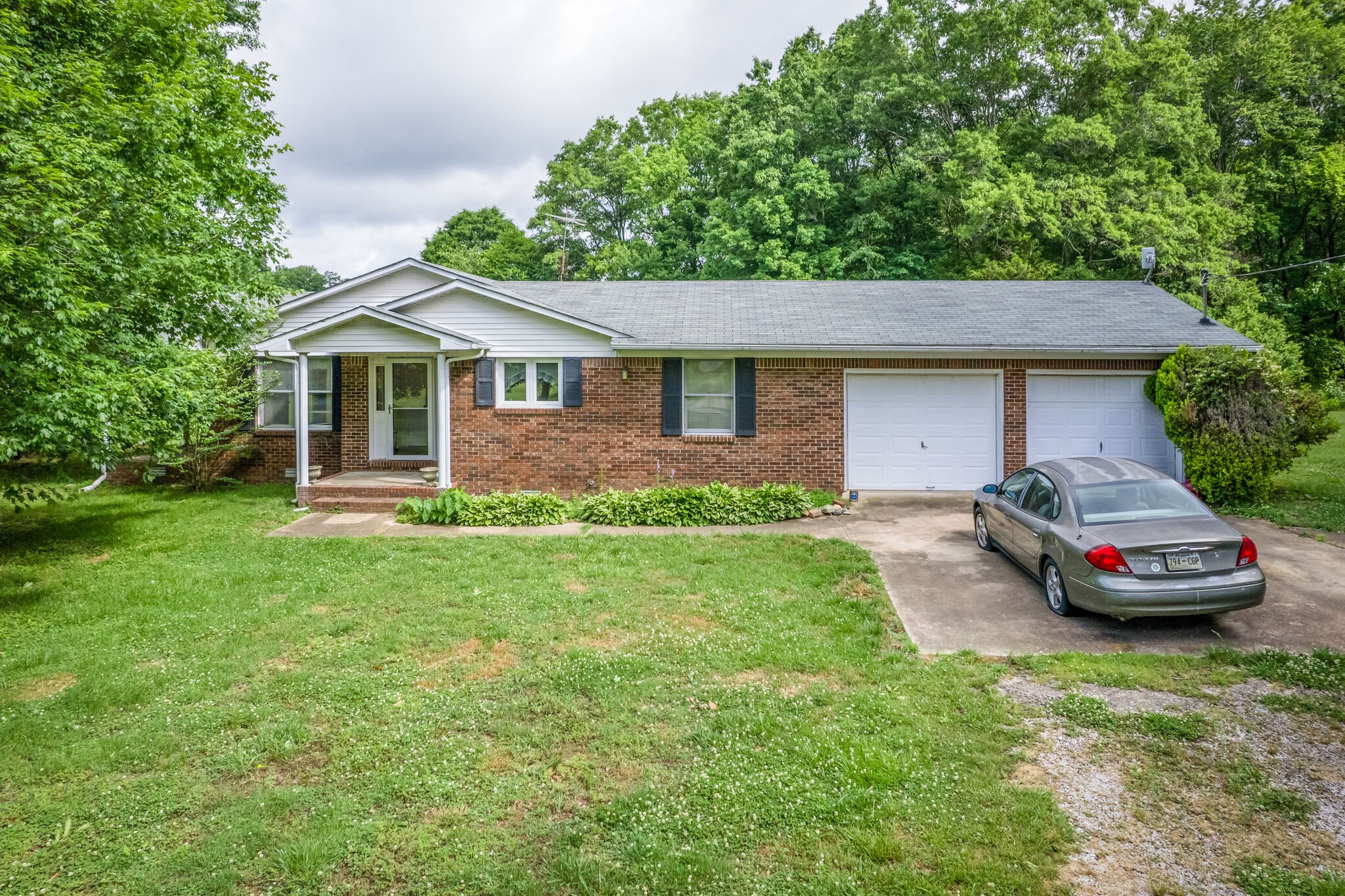 6200 Fall River Road Leoma, TN 38468 - Photo 2 of 29 a front view of a house with a garden and trees