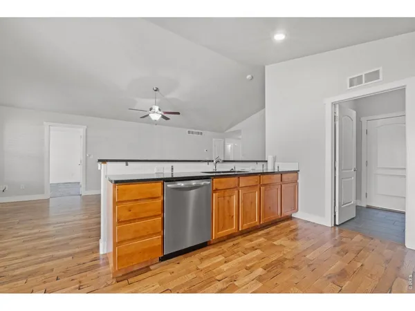 a open kitchen with a wooden floor and a sink