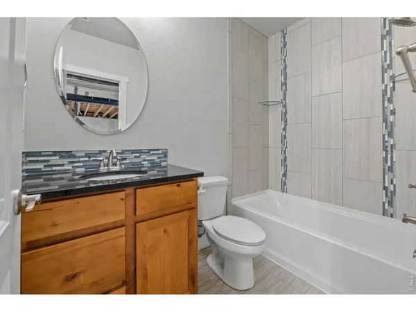 a bathroom with a granite countertop toilet a sink and bathtub