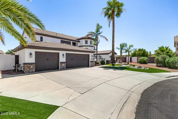 a view of a house with a yard and palm trees