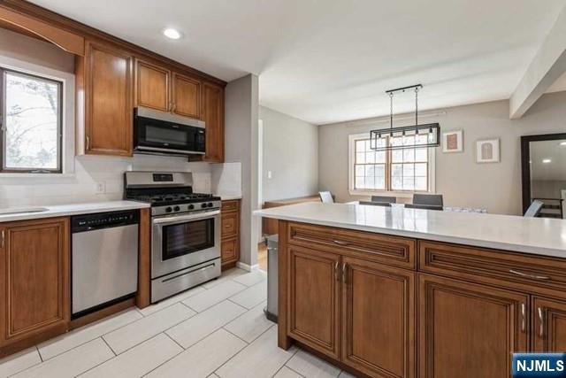 23 Asmus Road Closter, NJ 07624 - Photo 11 of 38 a kitchen with stainless steel appliances a stove sink microwave and cabinets