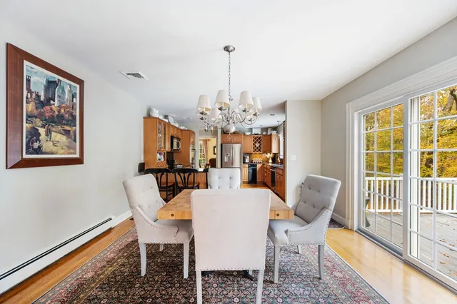 a view of a dining room with furniture a chandelier and wooden floor