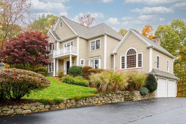 a view of a white house with a yard and potted plants