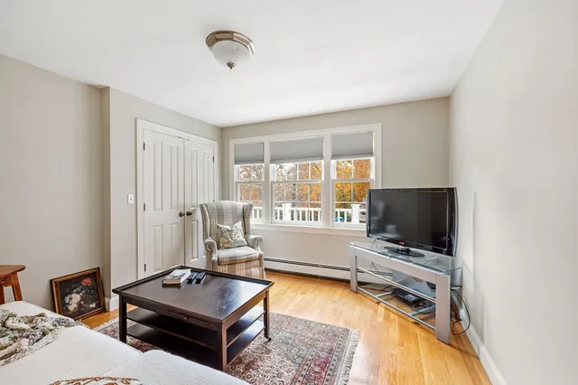 a living room with furniture flat screen tv and a window