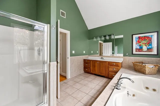 a bathroom with a tub sink and mirror
