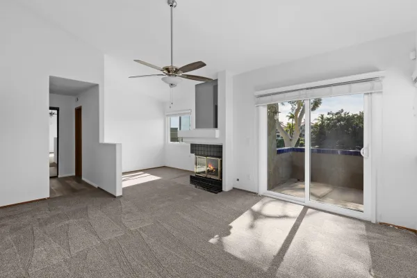 a view of an empty room with a fireplace and a window