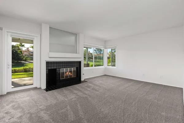 a view of an empty room with a window and a fireplace