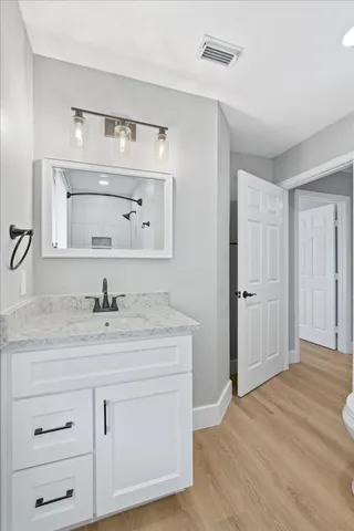 a bathroom with a granite countertop sink and a mirror
