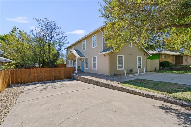 a view of a house with a yard and large tree