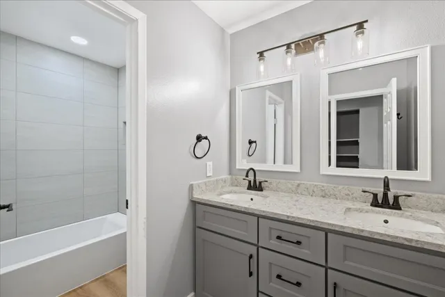 a bathroom with a tub sink and mirror