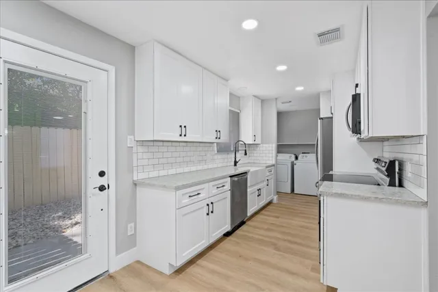 a kitchen with stainless steel appliances granite countertop a sink stove and refrigerator