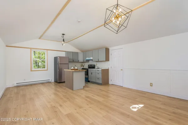 a kitchen with stainless steel appliances granite countertop a refrigerator sink and white cabinets