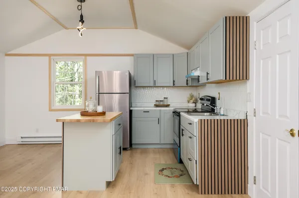a kitchen with stainless steel appliances granite countertop a refrigerator sink and stove
