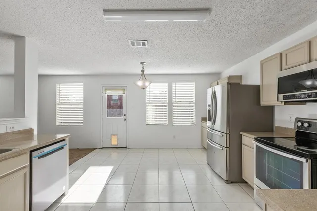 a kitchen with stainless steel appliances granite countertop a refrigerator and a stove top oven