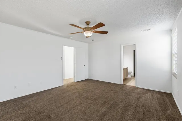 an empty room with closet and a ceiling fan