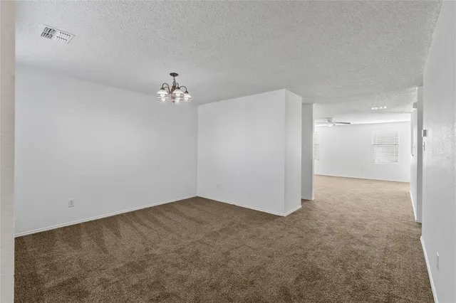 an empty room with a chandelier fan