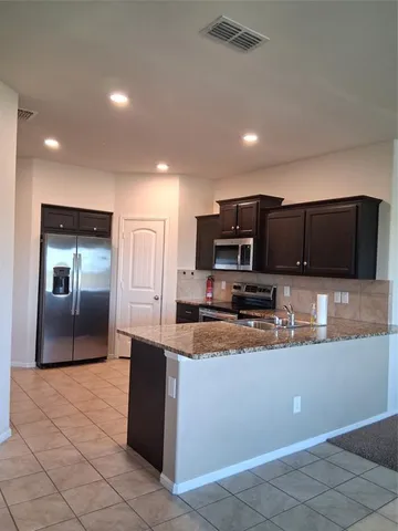 a large kitchen with stainless steel appliances lots of counter top space
