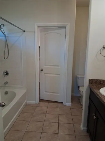 a bathroom with a granite countertop bathtub a toilet and a sink