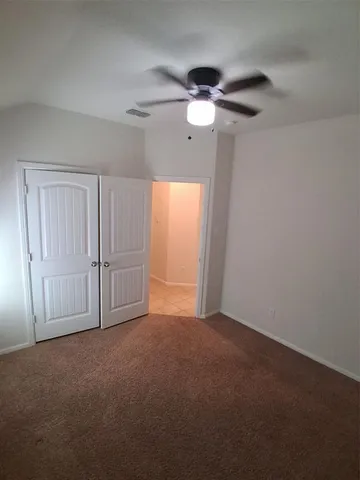 en empty room with windows and fan