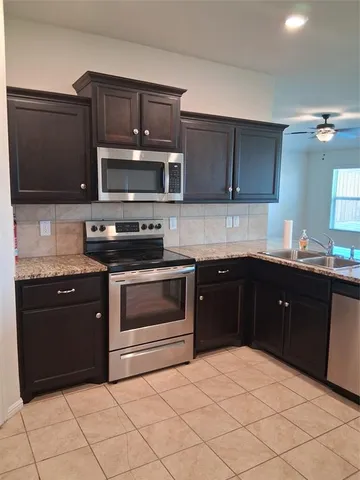 a kitchen with a sink stove and microwave