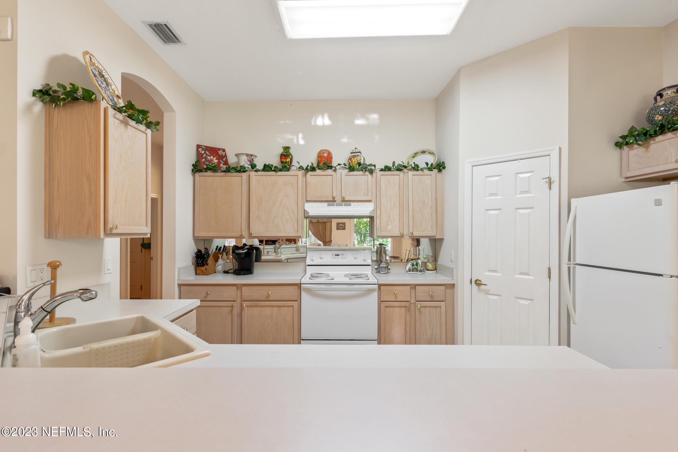 1796 Keswick Road St. Augustine, FL 32084 - Photo 10 of 48 a kitchen with a refrigerator a sink dishwasher with a dining table and chairs