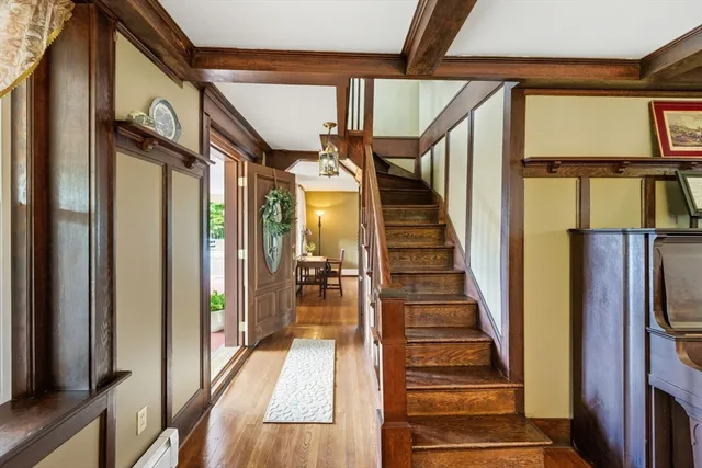 a view of staircase with lots of frames on wall and wooden floor