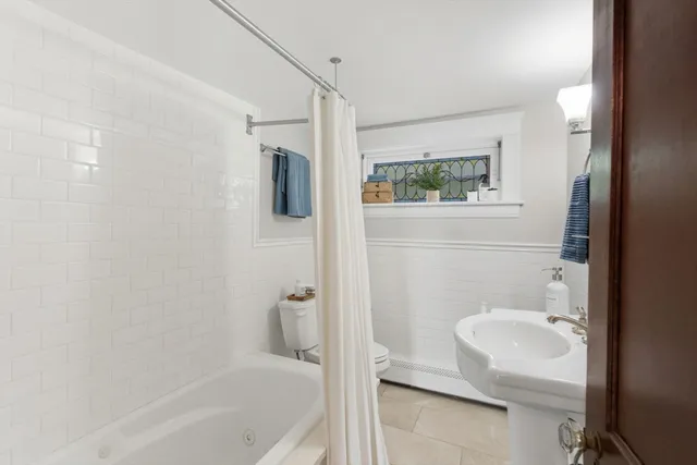 a bathroom with a shower a toilet and a sink