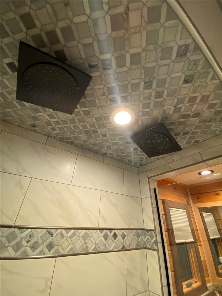 128 McAlister Road West Union, SC 29696 - Photo 18 of 40 Luxurious rain shower heads and exquisite tilework elevate this primary bathroom's design.