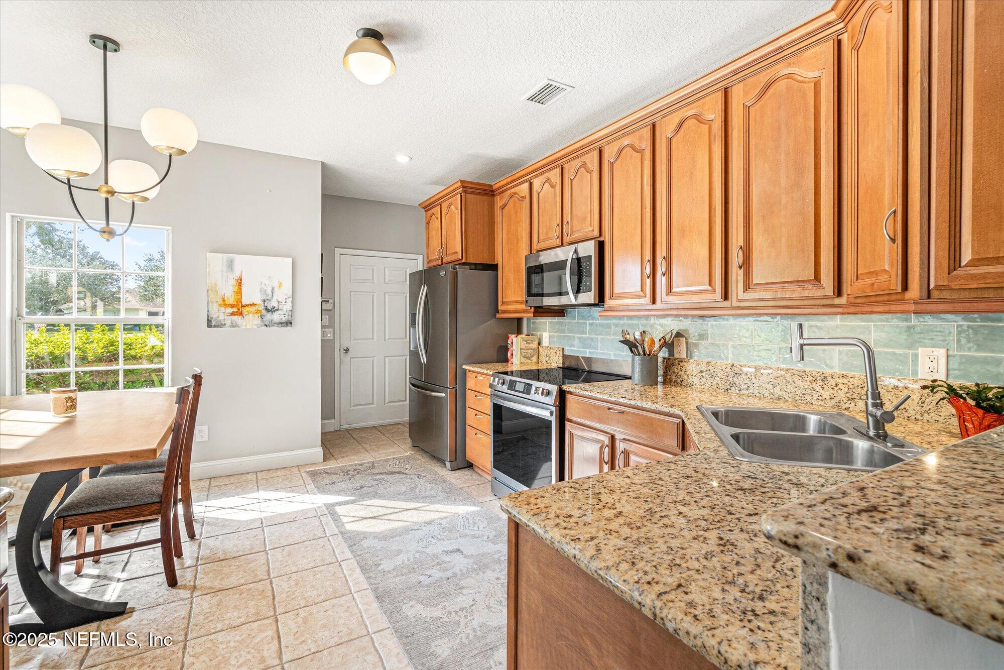 606 Teeside Court St. Augustine, FL 32080 - Photo 11 of 47 a kitchen with refrigerator cabinets and wooden floor