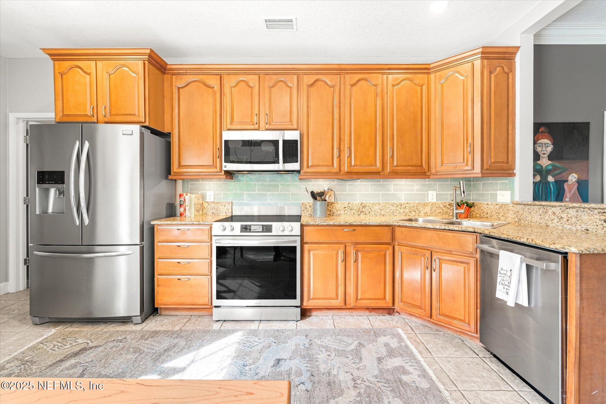 606 Teeside Court St. Augustine, FL 32080 - Photo 14 of 47 a kitchen with stainless steel appliances granite countertop a refrigerator stove and sink