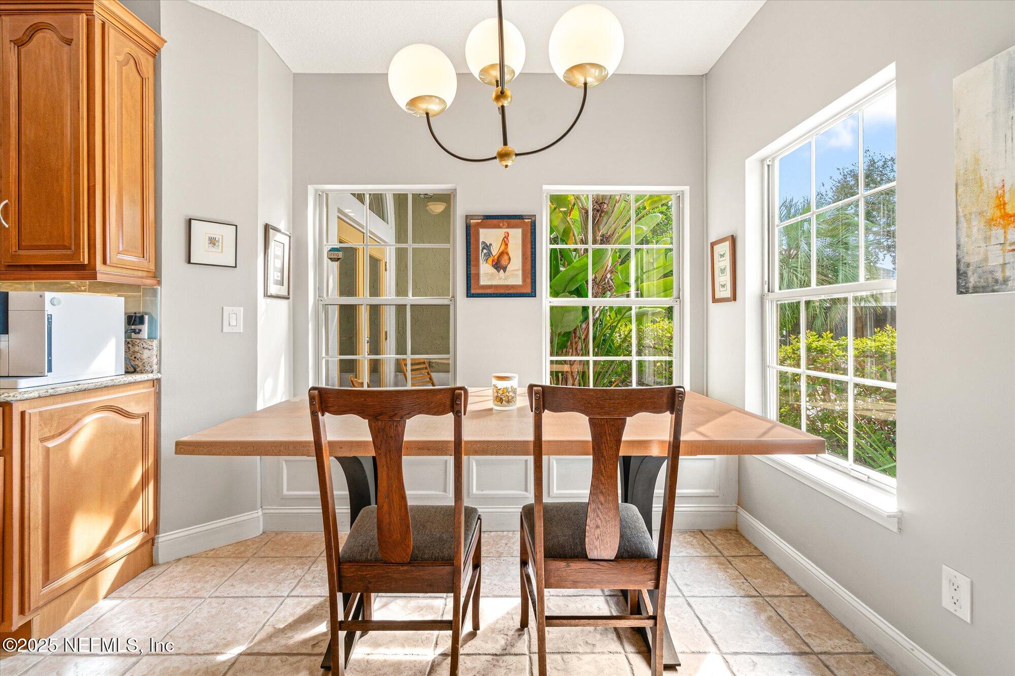606 Teeside Court St. Augustine, FL 32080 - Photo 16 of 47 a view of a dining room with furniture a chandelier and windows